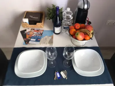 a table with two white plates and a bowl of fruit at La Joya de la Caleta. A 60 mts playa. in Cádiz