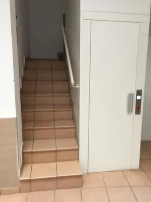 a hallway with stairs with a white cabinet and a door at La Joya de la Caleta. A 60 mts playa. in Cádiz