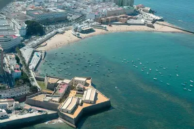 an aerial view of a beach with boats in the water at La Joya de la Caleta. A 60 mts playa. in Cádiz