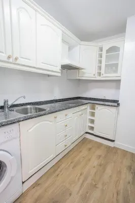 a kitchen with white cabinets and a sink at Pisoelpuerto in El Puerto de Santa María
