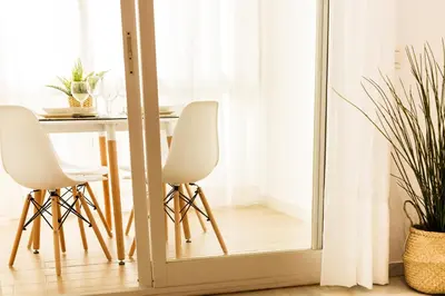 a mirror in a dining room with a table and white chairs at Pisoelpuerto in El Puerto de Santa María