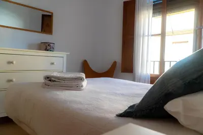 a bedroom with a bed with a dresser and a window at Light House Sherry in Jerez de la Frontera