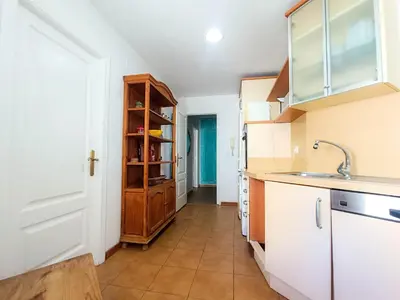 a kitchen with white cabinets and a sink at Light House Sherry in Jerez de la Frontera