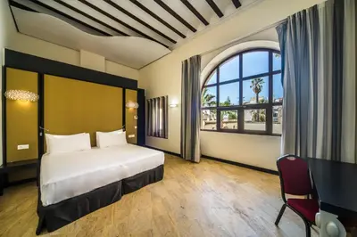 a bedroom with a bed and a large window at Hotel Palacio Marqués de Arizón in Sanlúcar de Barrameda