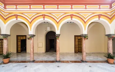 a lobby with columns and ceilings with plants at Hotel Palacio Marqués de Arizón in Sanlúcar de Barrameda