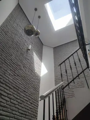 a staircase with a brick wall and a skylight at Luz de la Bahía San Fernando Cádiz in San Fernando