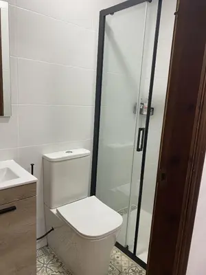 a bathroom with a toilet and a glass shower at Luz de la Bahía San Fernando Cádiz in San Fernando