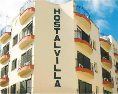 a building with a hotel sign on the side of it at Hostal Villa in Chiclana de la Frontera