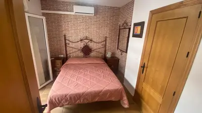 a small bed in a room with a brick wall at Casa Rural Los Pepe Sancti Petri in Chiclana de la Frontera