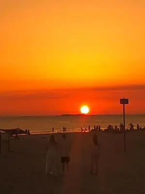 a group of people standing on the beach at sunset at Casa Rural Los Pepe Sancti Petri in Chiclana de la Frontera