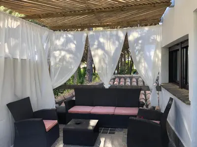 a porch with a couch and chairs and a window at Casa Rural Los Pepe Sancti Petri in Chiclana de la Frontera