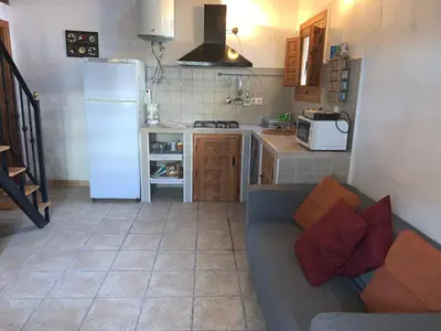a living room with a couch and a kitchen at Casa Rural Los Pepe Sancti Petri in Chiclana de la Frontera