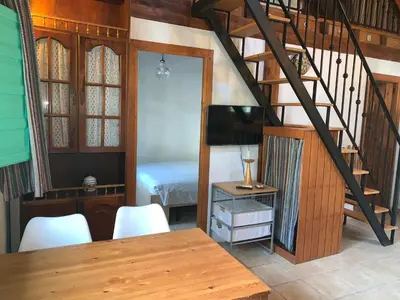 a room with a table and a bed and a staircase at Casa Rural Los Pepe Sancti Petri in Chiclana de la Frontera