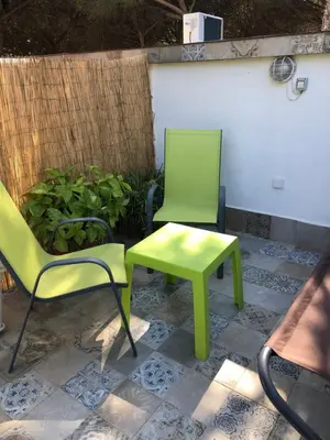 two chairs and a table and a green table and chair at Casa Rural Los Pepe Sancti Petri in Chiclana de la Frontera