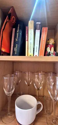 a shelf with books and wine glasses on it at Reina Mercedes in Chipiona