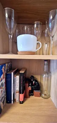a shelf with wine glasses and books and a bottle at Reina Mercedes in Chipiona