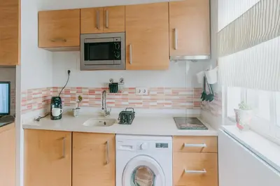 a kitchen with a sink and a washing machine at Reina Mercedes in Chipiona