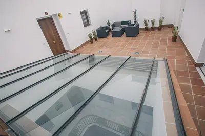 a glass floor in a living room with couches at Apartamentos casa palacio in El Puerto de Santa María