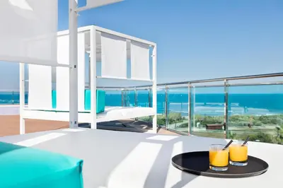 a table with two glasses of orange juice on a balcony at Hotel Best Costa Ballena in Costa Ballena