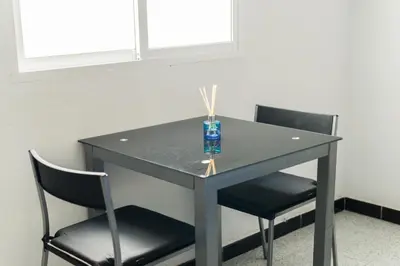 a black table with two chairs and a vase on it at Coqueto estudio in Cádiz