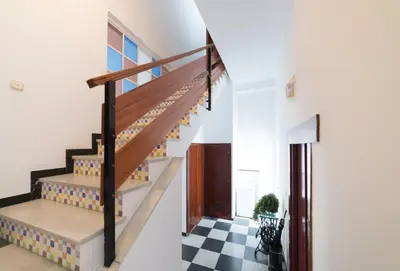 a staircase in a house with a checkered floor at Coqueto estudio in Cádiz