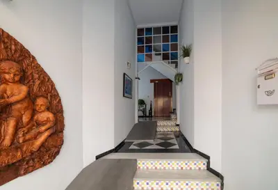 a hallway with a stairway with a painting of babies on the wall at Coqueto estudio in Cádiz