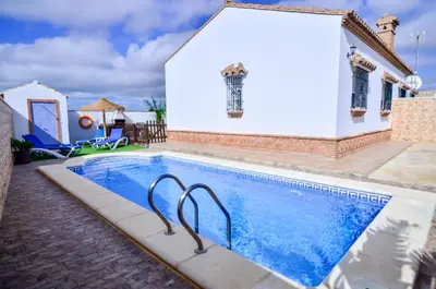 a swimming pool in front of a house at Casa Manoli in Conil de la Frontera