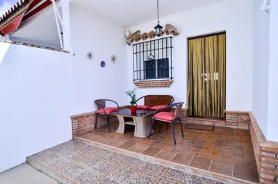 a patio with a table and chairs and a door at Casa Manoli in Conil de la Frontera