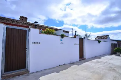 a white fence with a gate and flowers on it at Casa Manoli in Conil de la Frontera