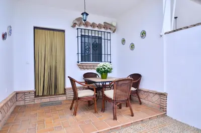 a patio with a table and chairs and a window at Casa Manoli in Conil de la Frontera