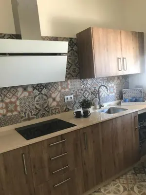 a kitchen with wooden cabinets and a sink at Villa Chill In in Chiclana de la Frontera
