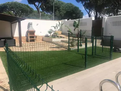 a fence with green posts in a yard at Villa Chill In in Chiclana de la Frontera