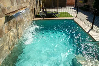 a plunge pool with a waterfall in a backyard at Villa Nueva Cascada - Casa Rustica 