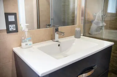 a bathroom with a white sink and a mirror at Villa Nueva Cascada - Casa Rustica 