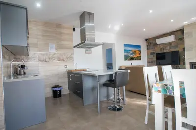 a kitchen with a counter and a sink and a table at Villa Nueva Cascada - Casa Rustica 