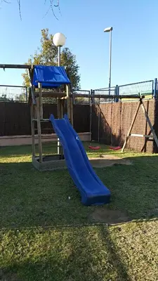 a playground with a blue slide in a park at Apartamento Estrella in Sanlúcar de Barrameda