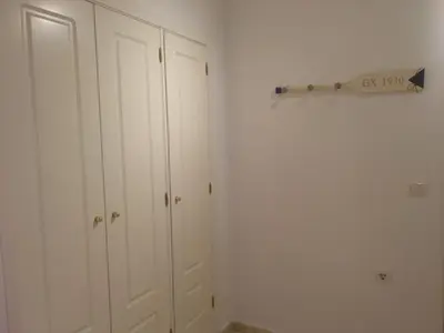 a bedroom with white cabinets and a sign on the wall at Apartamento Estrella in Sanlúcar de Barrameda