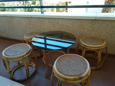 a table and chairs and a table with a surfboard on it at Apartamento Estrella in Sanlúcar de Barrameda