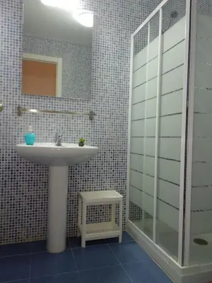 a bathroom with a sink and a shower and a mirror at Apartamento Estrella in Sanlúcar de Barrameda