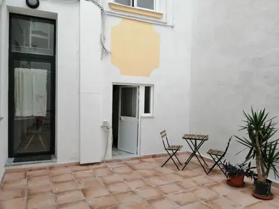 a patio with chairs and a table and a building at Lofts Miriam in Cádiz