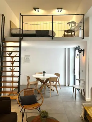 a room with a table and chairs and bunk beds at Lofts Miriam in Cádiz
