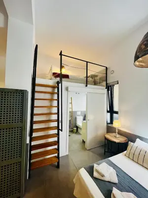 a bedroom with a loft bed and a staircase in a room at Lofts Miriam in Cádiz