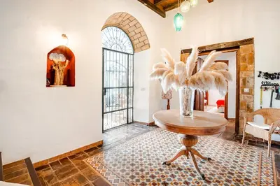 a room with a table and a vase with feathers on it at Casa palacio reformada S.XVIII in Sanlúcar de Barrameda