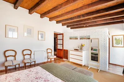 a bedroom with a bed and chairs in a room at Casa palacio reformada S.XVIII in Sanlúcar de Barrameda