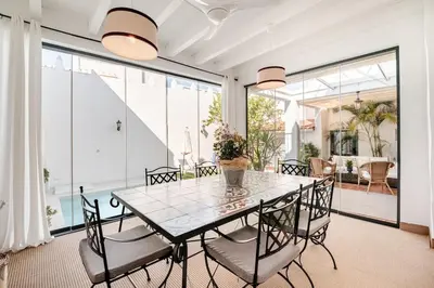 a dining room with a glass table and chairs at Casa palacio reformada S.XVIII in Sanlúcar de Barrameda