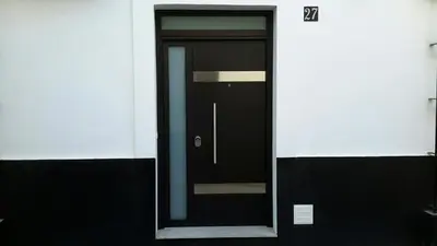 a black door on the side of a building at La Pandorga in Sanlúcar de Barrameda