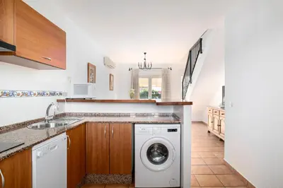 a kitchen with a washing machine and a sink at Apartamentos Los Olivos in Conil de la Frontera