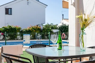 a table with two glasses and a bottle of wine at Apartamentos Los Olivos in Conil de la Frontera