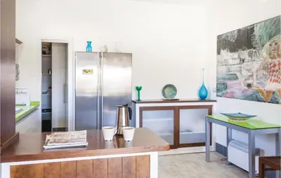 a kitchen with a refrigerator and a wooden table at Nice Home In Arcos De La Frontera in Arcos de la Frontera