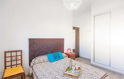 a bedroom with a bed with a blue book on it at Nice Home In Arcos De La Frontera in Arcos de la Frontera